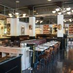 a restaurant with tables and chairs and a bar.