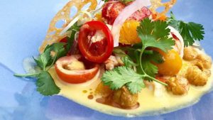 a blue plate topped with meat and vegetables.