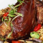 a white plate topped with meat and vegetables.
