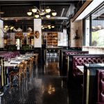 a restaurant filled with lots of tables and chairs.
