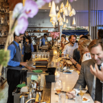 a group of people standing around a bar.