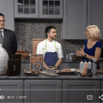 a group of people standing around a kitchen counter.