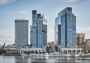 a group of tall buildings sitting next to a body of water.