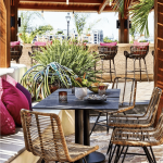 a patio with wicker chairs and a table.