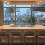a kitchen with a large wooden table surrounded by chairs.