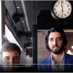 a man with a beard standing next to a clock.
