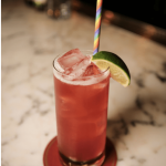 a drink with a lime slice and a straw.
