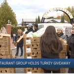 a group of people standing around boxes of food.