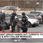 a group of people standing in a parking lot.