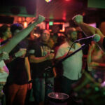 A man is singing in front of a crowd of people.