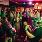 A group of people in a bar playing music.