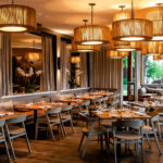 The interior of a restaurant with wooden tables and chairs.