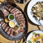 a wooden table topped with plates of food.