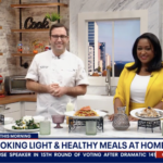 a couple of people standing in a kitchen.