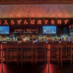 a dimly lit bar with a lot of bottles on it.