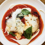 a white plate topped with meat covered in sauce.