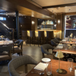 a restaurant with tables and chairs and a bar.