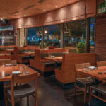 a restaurant with wooden tables and chairs.