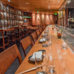 a restaurant with a long wooden table and chairs.