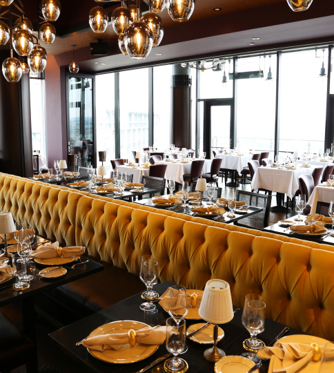 a restaurant with a long yellow banquet table.