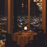 a table with a white table cloth on it in front of a window overlooking a.