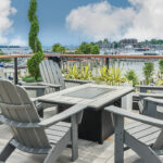 a table and chairs on a balcony overlooking a harbor.