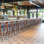 a bar with a bunch of chairs and a bunch of bottles.