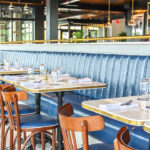 a restaurant with blue walls and wooden chairs.