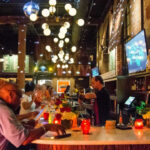 a group of people sitting at a bar.