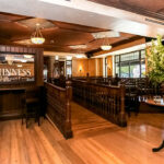 a restaurant with wooden floors and tables and chairs.