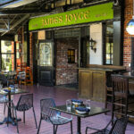 a restaurant with tables, chairs, and a bar.
