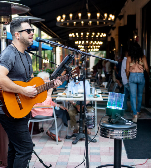 a man playing a guitar in front of a microphone.