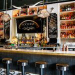 a bar with lots of bottles of liquor behind it.
