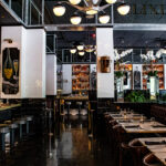 a dimly lit restaurant with tables and chairs.