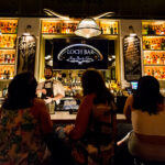a group of people sitting at a bar.