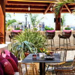 a covered patio with a table and chairs.
