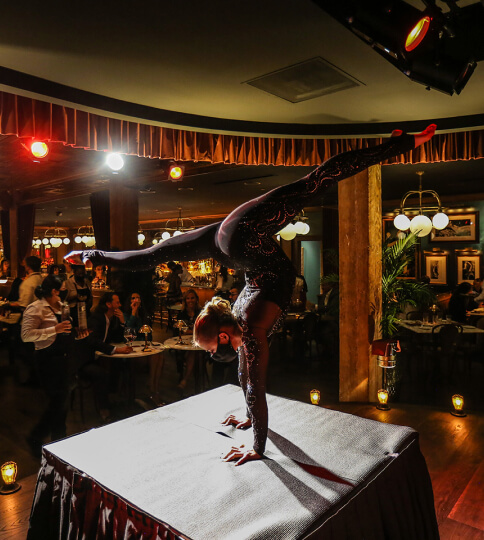 a woman doing a handstand on top of a table.