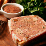 a wooden cutting board topped with meat and a fork.