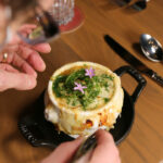 a person holding a fork over a plate of food.