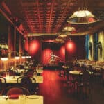 a restaurant with red walls and tables and chairs.