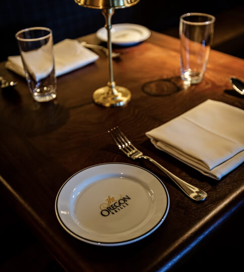 a table set with a plate, silverware, and napkins.