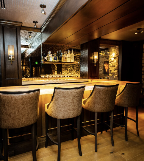 a bar with a bunch of chairs around it.