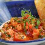 a bowl of food with bread on the side.