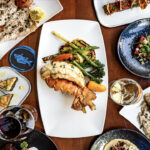 a wooden table topped with plates of food.