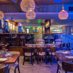 a restaurant with many tables and chairs in it.