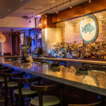 a bar with a bunch of bottles on the wall.