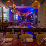 a dimly lit restaurant with wooden tables and chairs.
