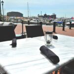 a table and chairs with a view of a harbor.