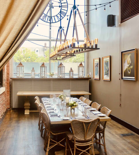 a dining room with a large table and a clock on the wall.