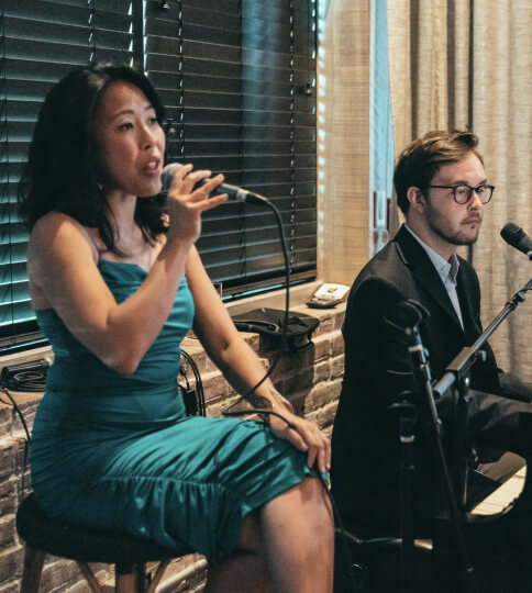 a man and a woman sitting in front of microphones.